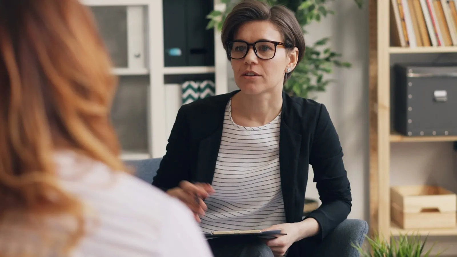 Licensed therapist in session with an older adult patient by video